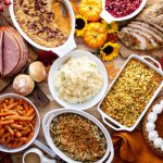 Thanksgiving,Table,With,Roasted,Turkey,,Sliced,Ham,And,Side,Dishes